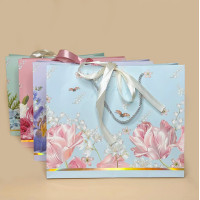 Подарунковий пакет з квітковим дизайном і стрічкою S