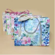 Подарунковий пакет з ніжним квітковим дизайном і стрічкою