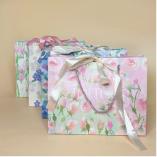 Подарунковий пакет з ніжним квітковим дизайном і стрічкою