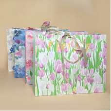 Подарунковий пакет з ніжним квітковим дизайном і стрічкою