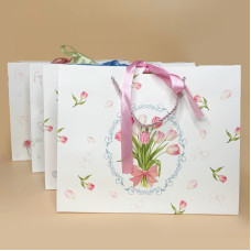 Подарунковий пакет з ніжним квітковим дизайном і стрічкою