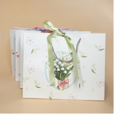 Подарунковий пакет з ніжним квітковим дизайном і стрічкою