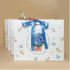 Подарунковий пакет з ніжним квітковим дизайном і стрічкою