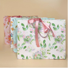 Подарунковий пакет з ніжним квітковим дизайном і стрічкою